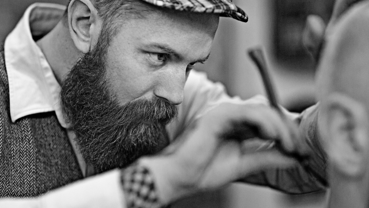 Barber performing a close shave using a straight razor with a single edge barber blade on a client.